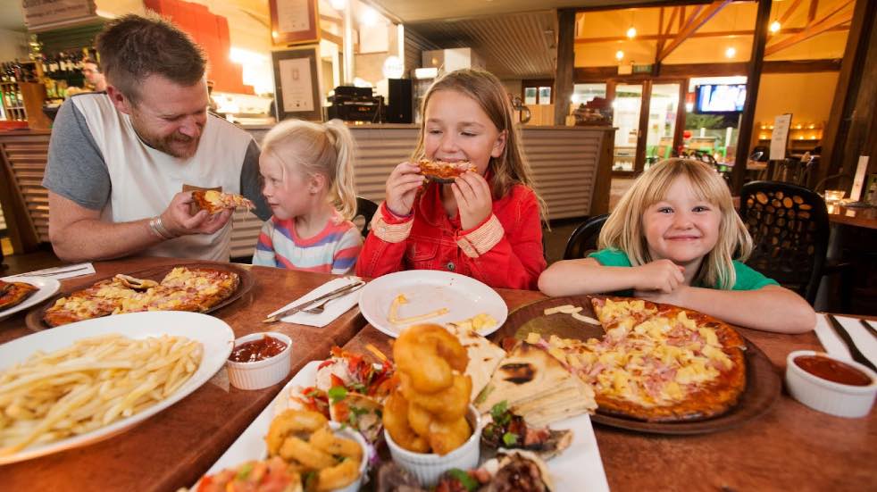 Father and children eating pizza